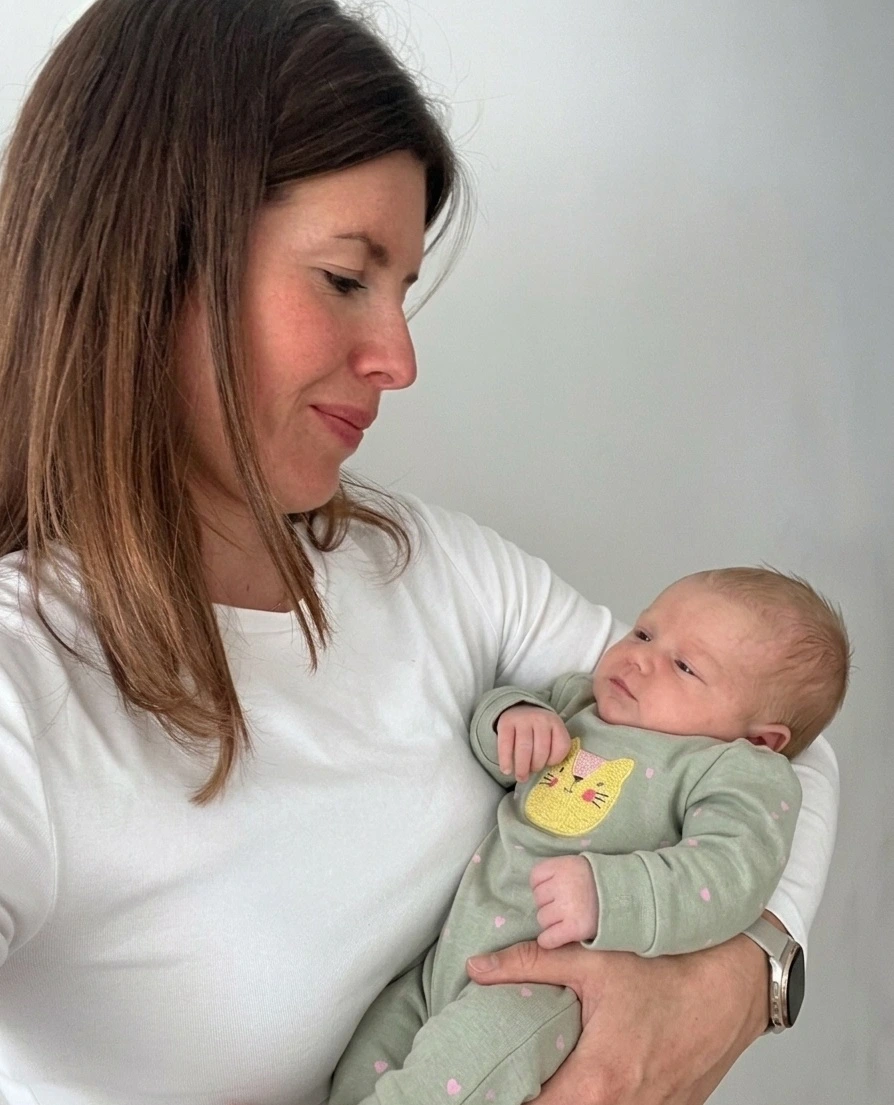 Baby-Handling — Ivana Remenar Simunec trägt ein Baby beim Hausbesuch in München